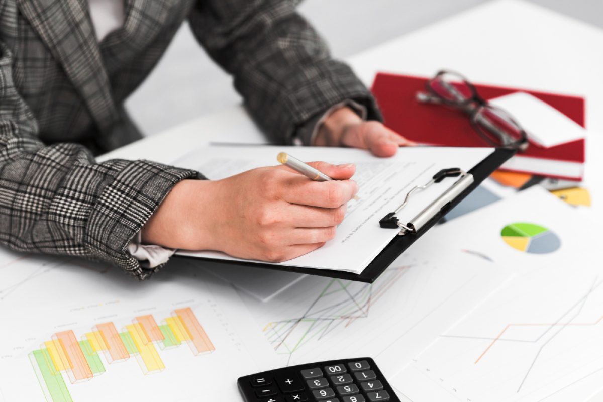 A person working on construction estimating with charts and a calculator nearby.