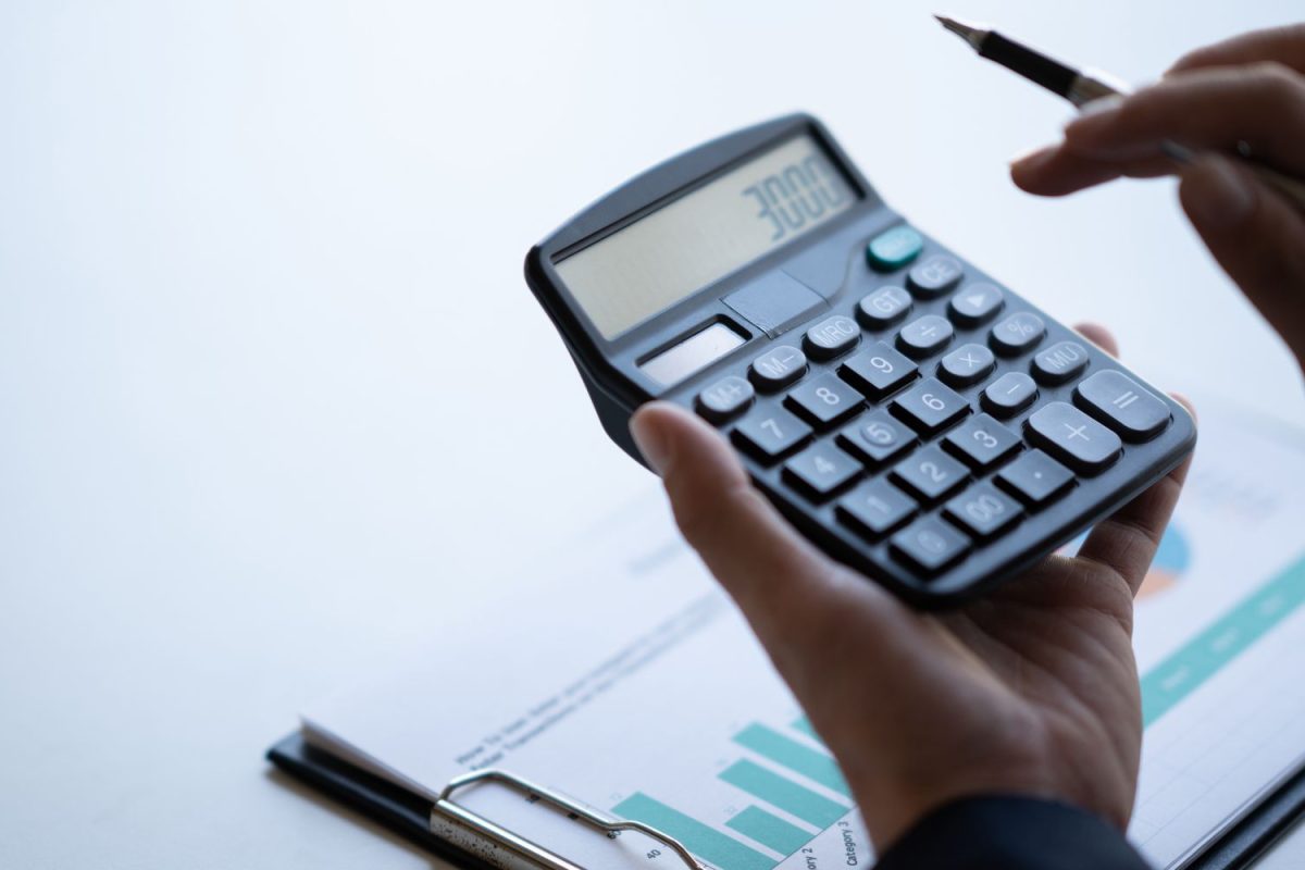 Image of a person holding a calculator displaying '3000' and using a pen, with a chart in the background. The visual can represent financial planning or budgeting, symbolizing the need to calculate how much does an estimate cost for a project or service.